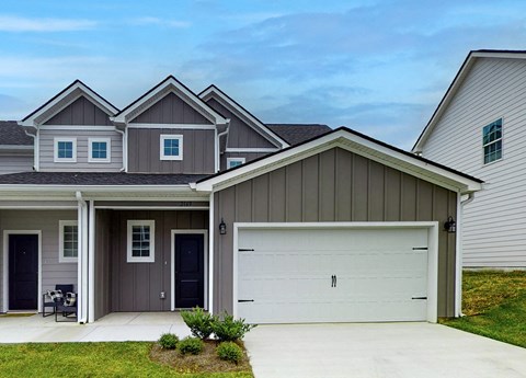 A house with a grey garage door and a grey house.
