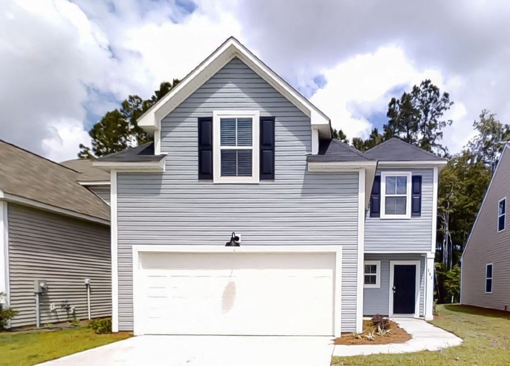 A two-story house with a garage door and a driveway.