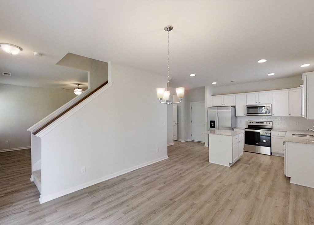 A modern kitchen with a staircase leading to the upper floor.