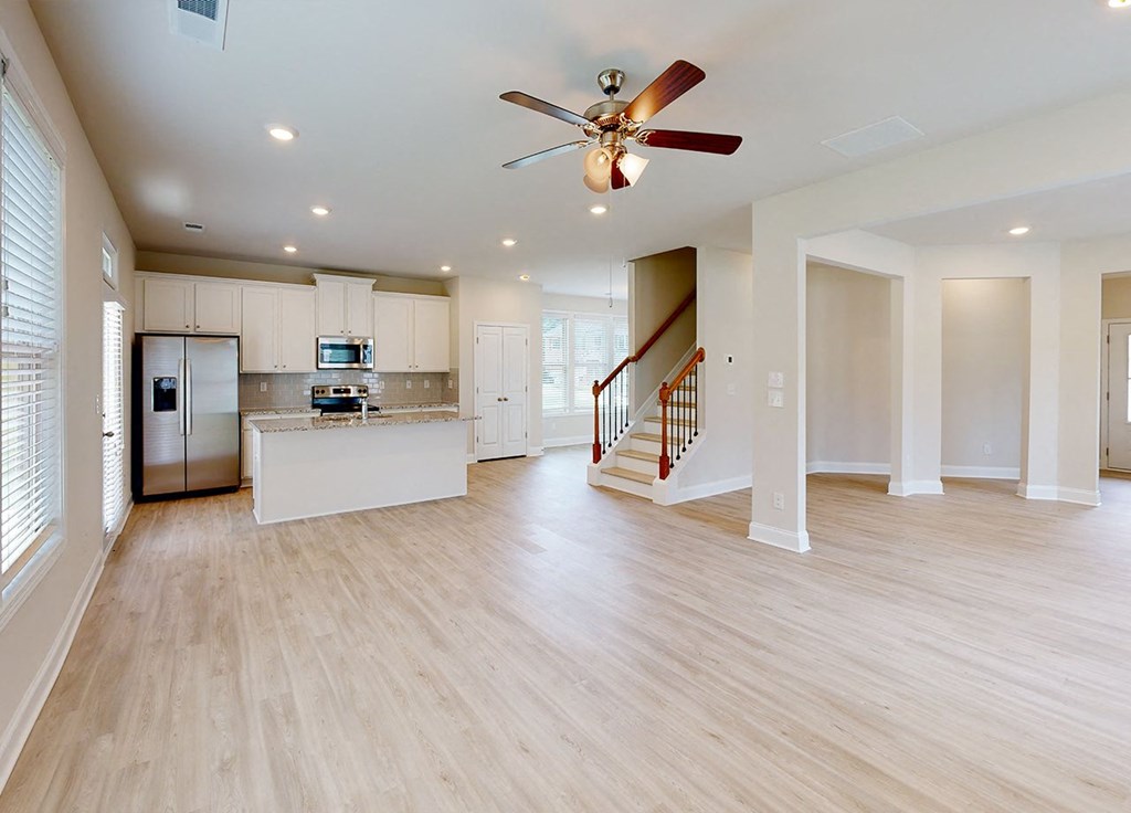A spacious kitchen with a refrigerator, microwave, and stove top oven.