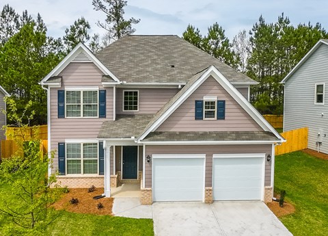 A two-story house with a garage and a driveway.