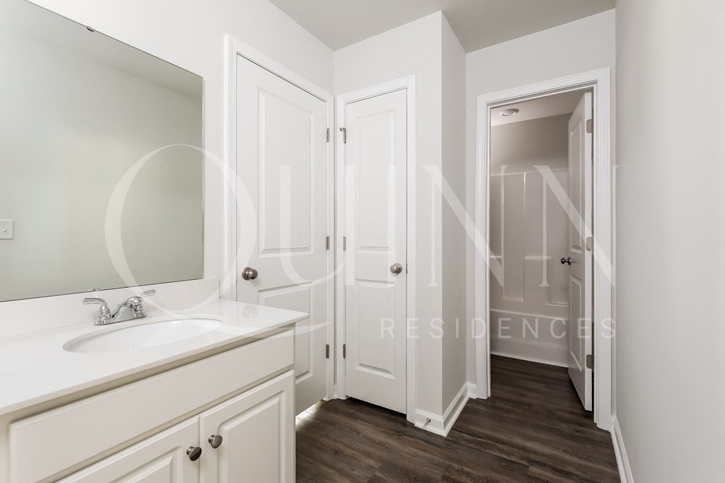 a bathroom with white cabinets and a white sink