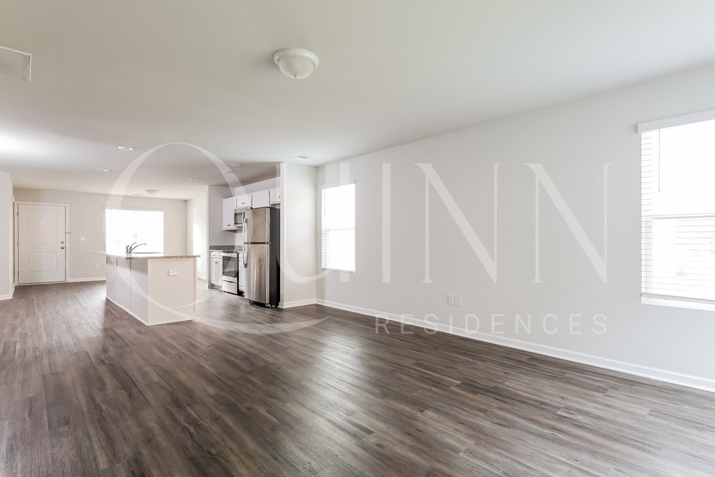 living room with hardwood floors and a kitchen in the background