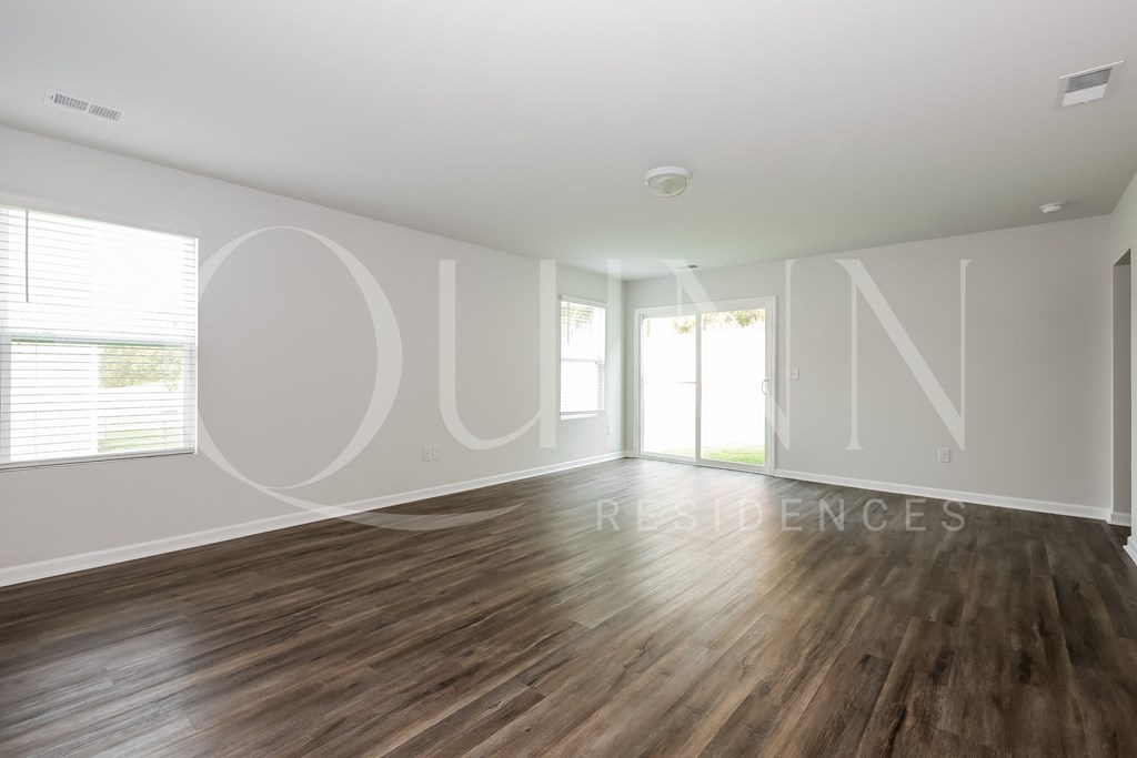 a living room with hardwood floors and white walls