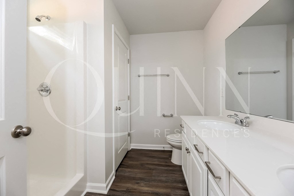 a walk in closet in a bathroom with a white sink and toilet