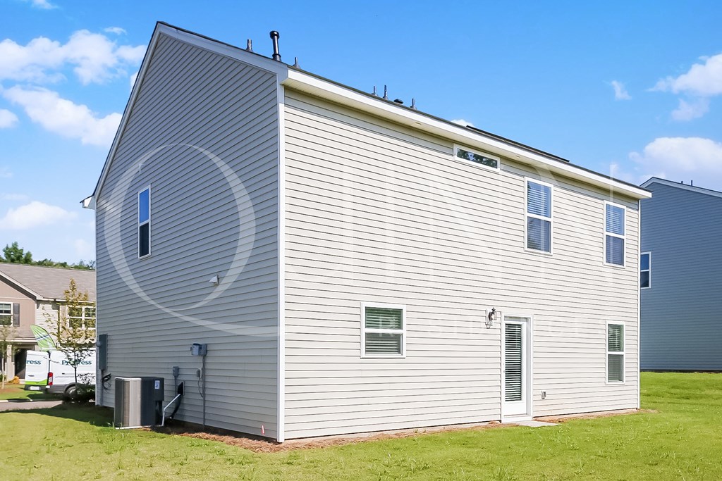 a large white building with a gray siding and a gray roof