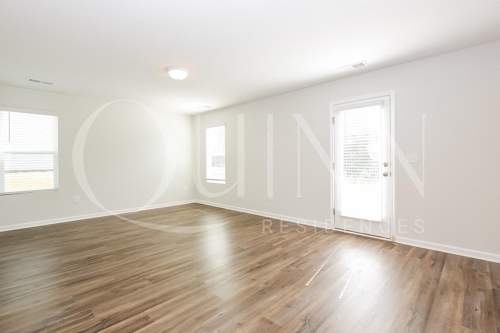 a bedroom with hardwood floors and white walls