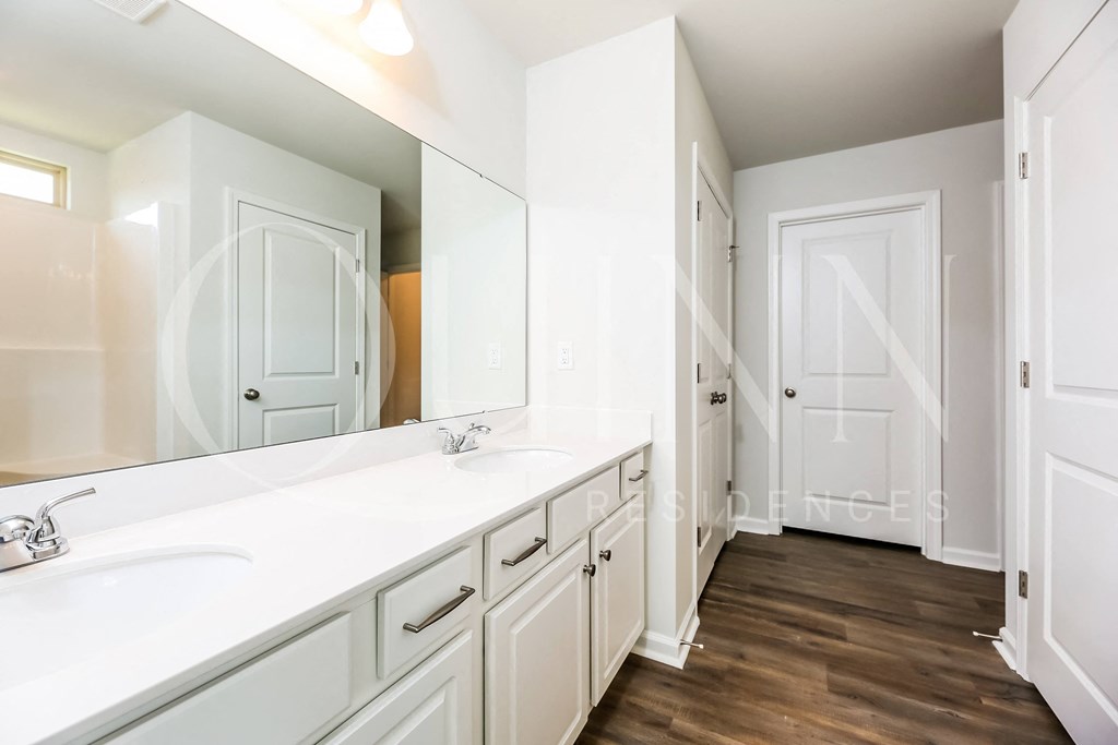a large bathroom with two sinks and a large mirror