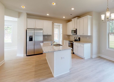 A kitchen with white cabinets and a center island.