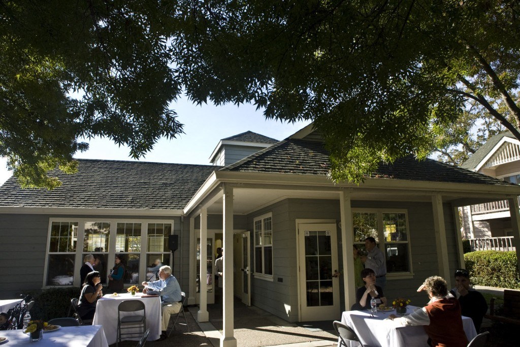 a group of people sitting at tables outside of a building