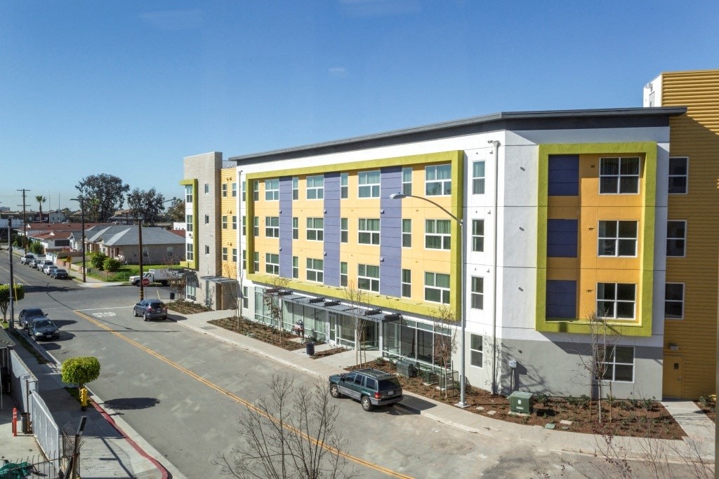 a building with a yellow and white facade and a parking lot