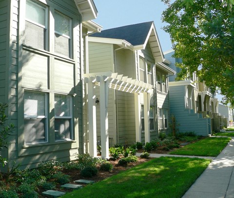 a row of houses with a sidewalk in front of them