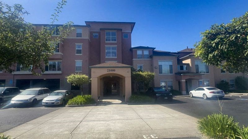 an apartment building with cars parked in front of it