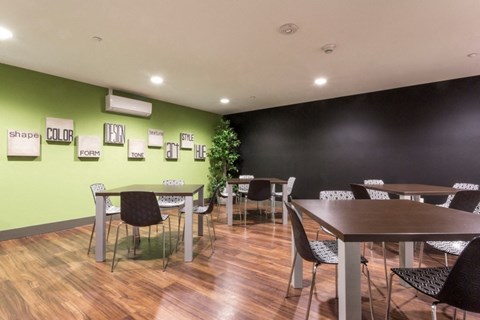 a dining room with tables and chairs and a green wall