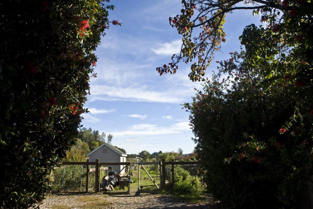 a view of a farm with a gate and a motorcycle in the field