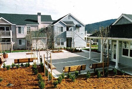 a group of houses with a courtyard with benches
