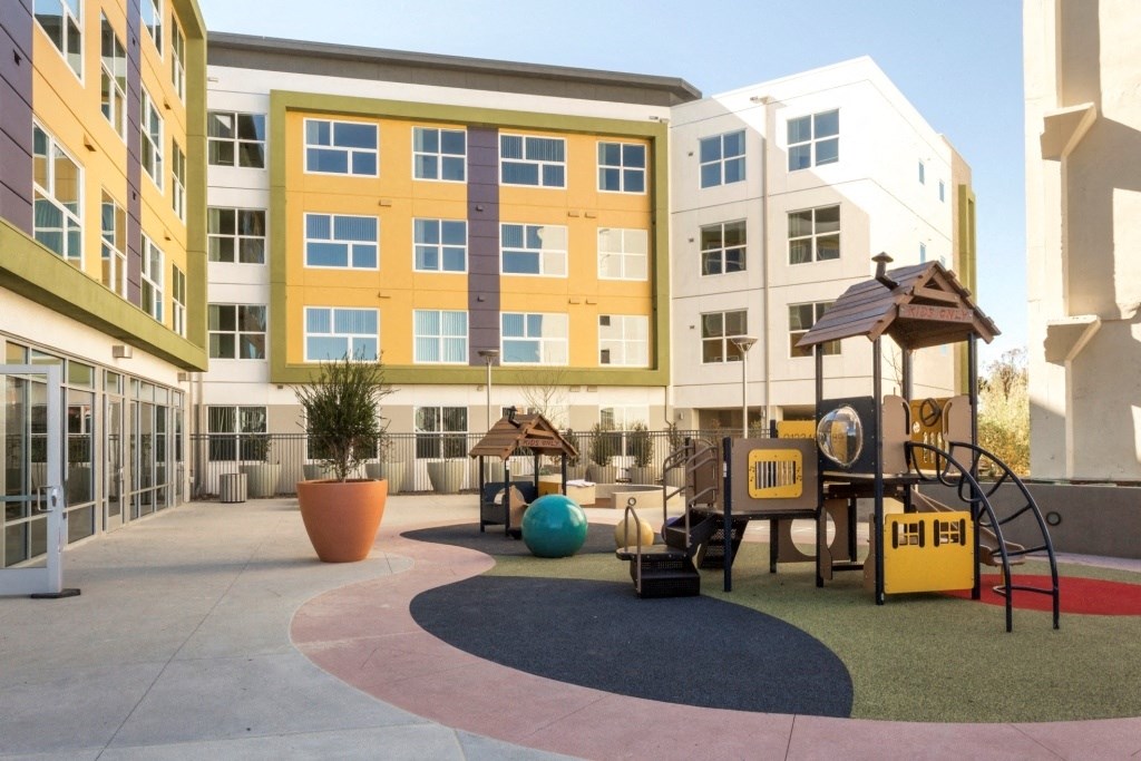 an image of a playground in front of an apartment building