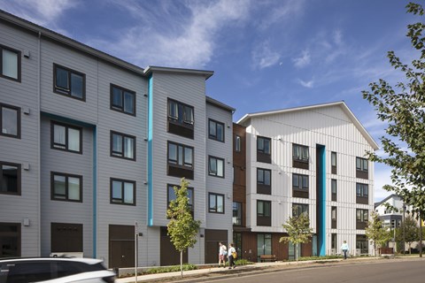 A modern apartment building with a white exterior and blue accents.
