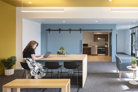 A woman is working on her laptop in a modern office space.