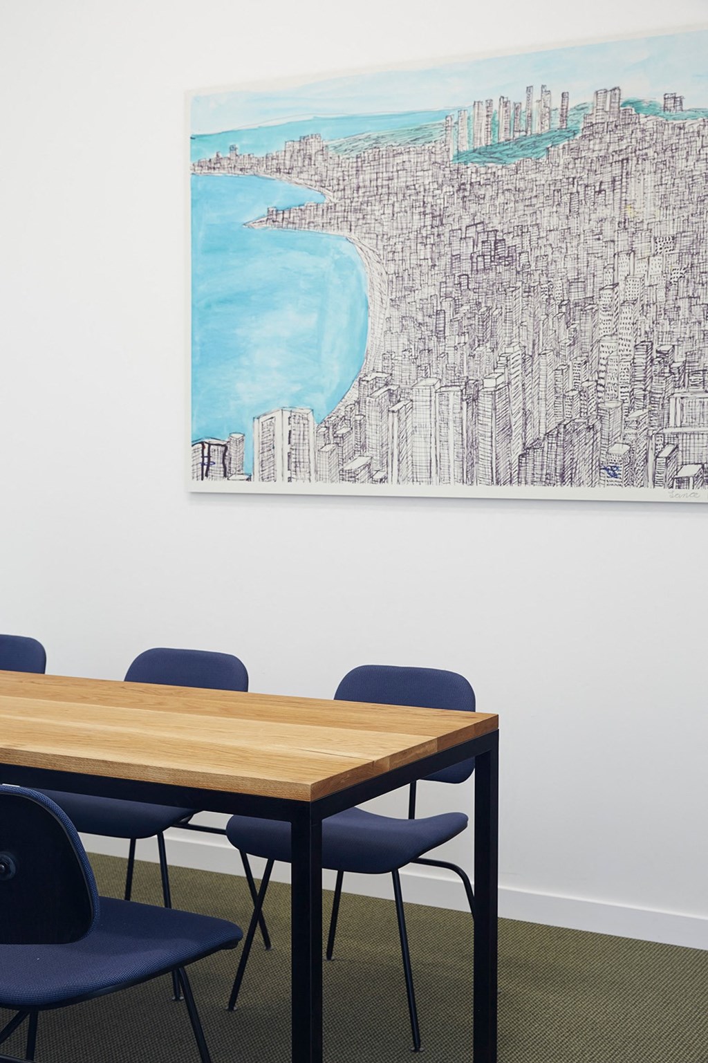 a conference room with a table and chairs and a painting on the wall