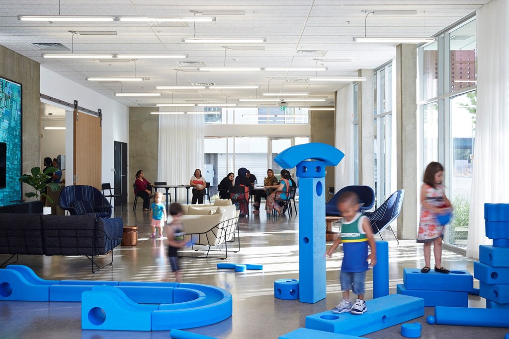 children playing in the lobby of a building with blue structures