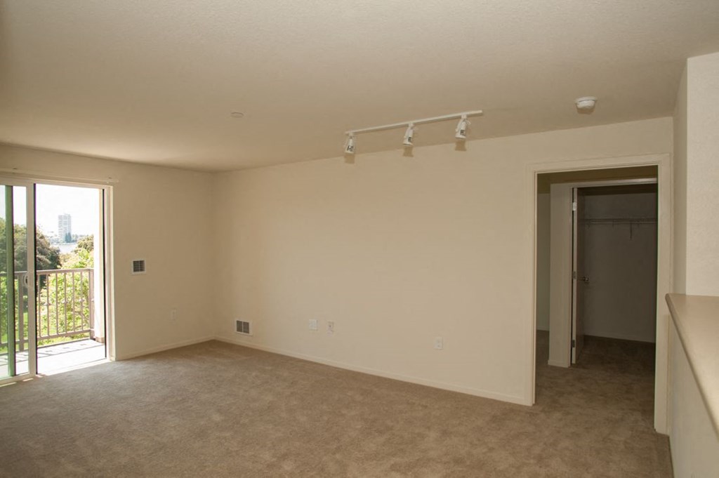 an empty living room with lights on the ceiling