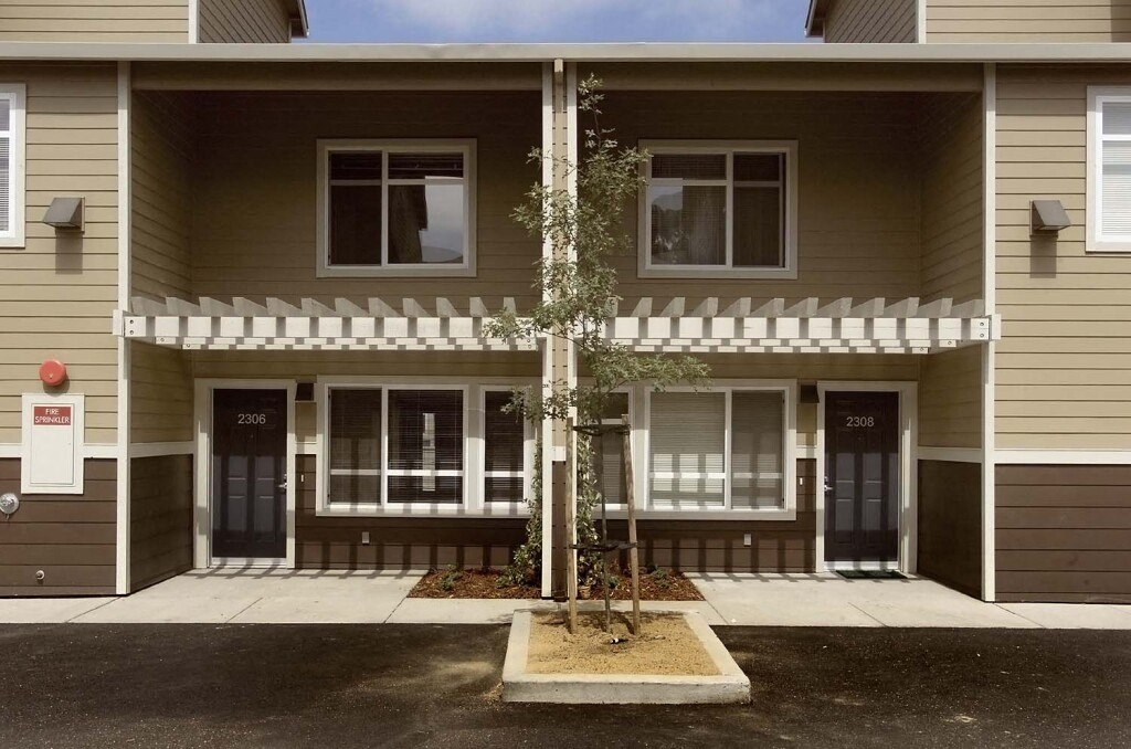 the front of a house with a tree in front of it
