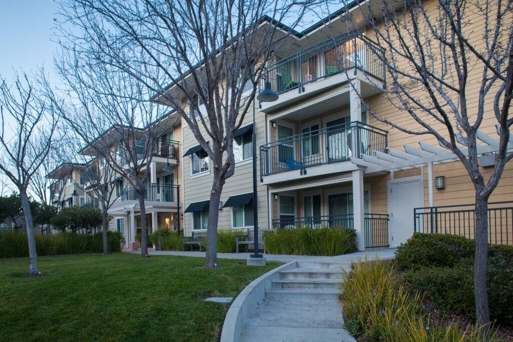 a row of apartments with balconies and trees