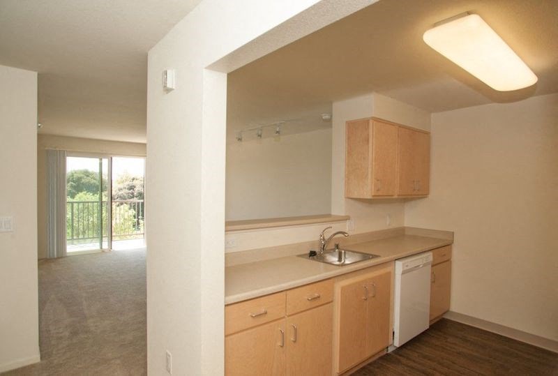 an empty kitchen with wooden cabinets and a sink