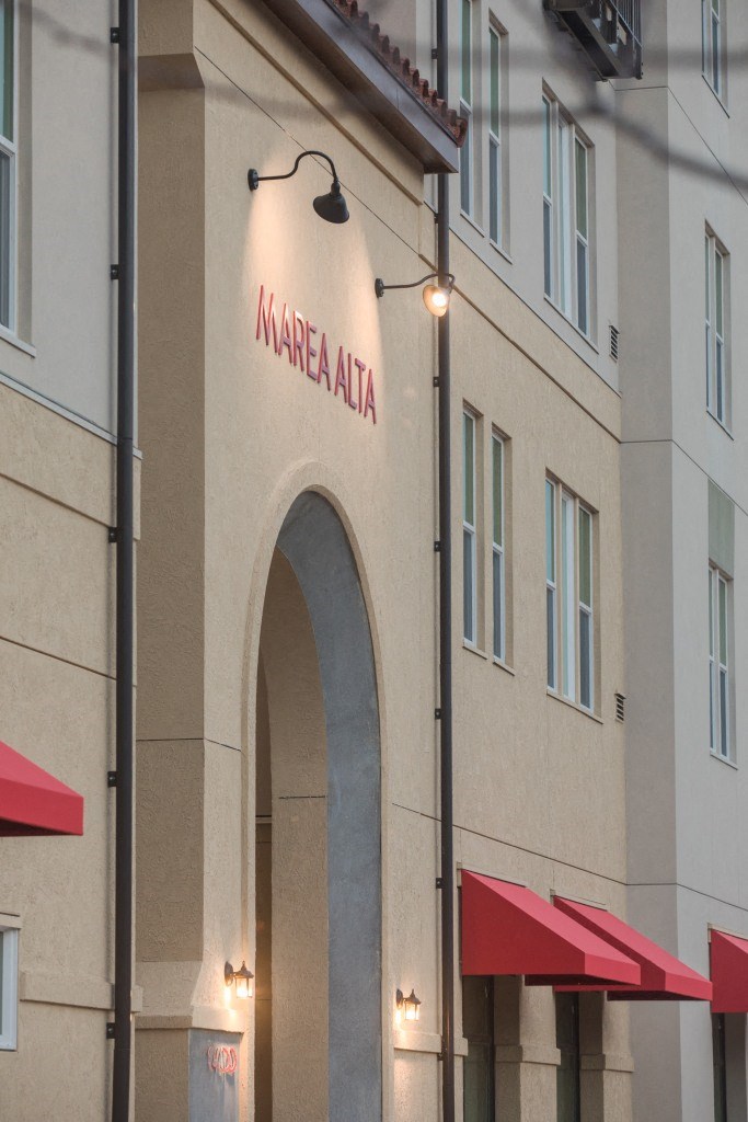 the facade of a building with red umbrellas in front of it