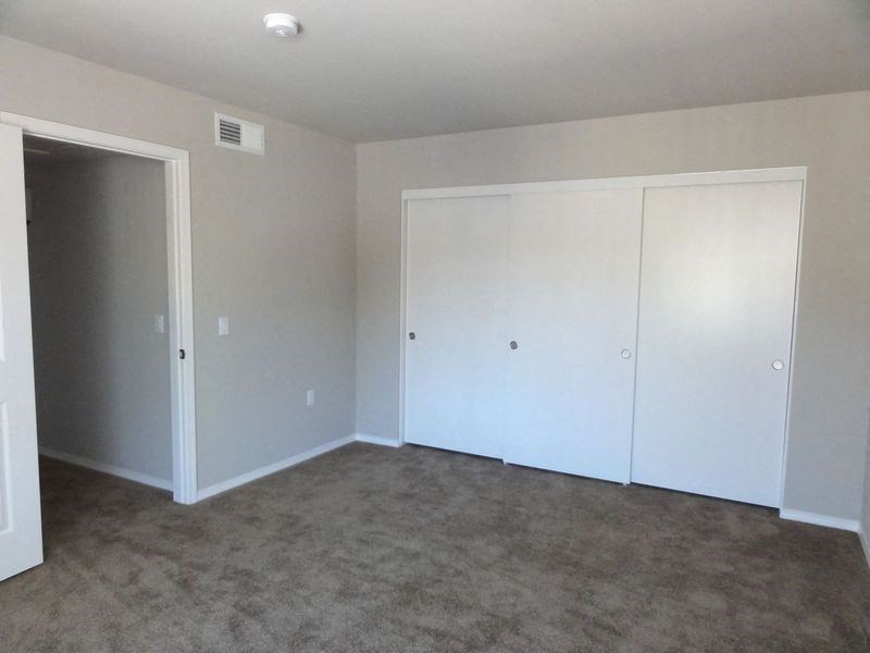 an empty living room with white walls and carpet
