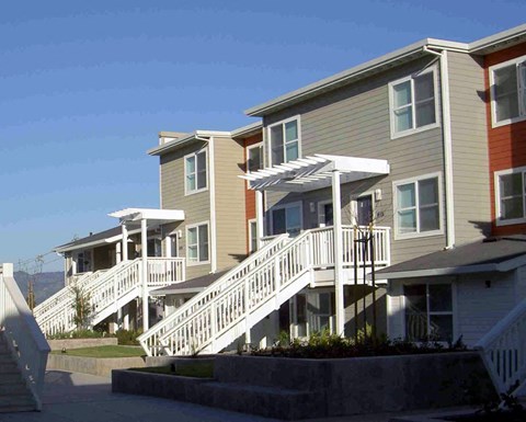 a row of houses with stairs on the side of a street