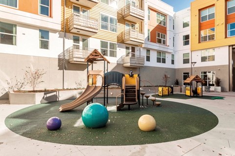 a playground with a slide and balls in an apartment building