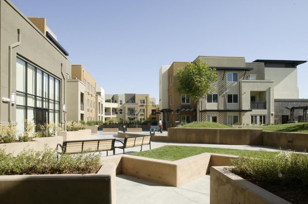 a park with benches and buildings in the background