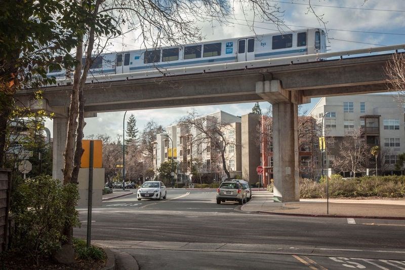 a train on a bridge over a city street