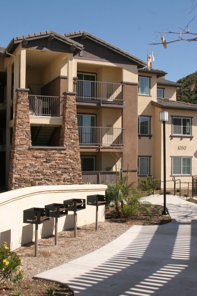 an apartment building with a bench in front of it