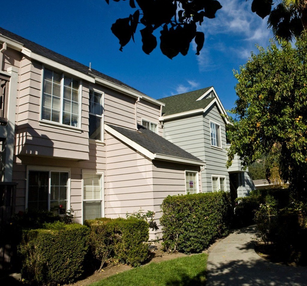the exterior of a house with a sidewalk in front of it