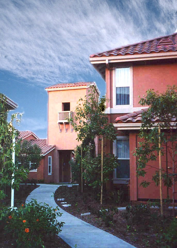 a house with a sidewalk and trees in front of it