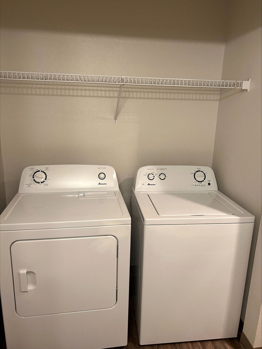 Two white front loading washing machines in a laundry room.