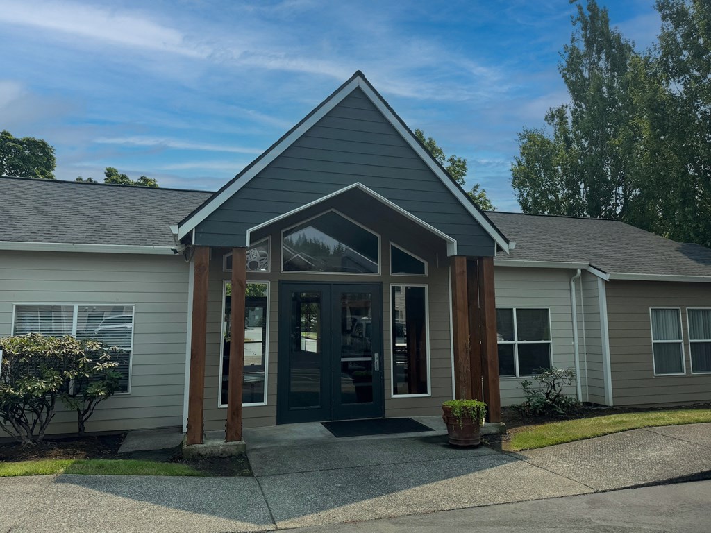 the front of a gray house with a porch and glass doors