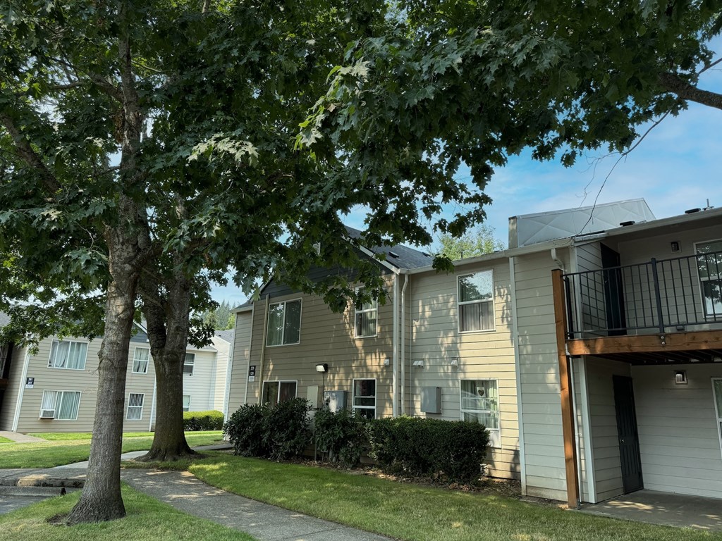 an apartment building with a tree in front of it