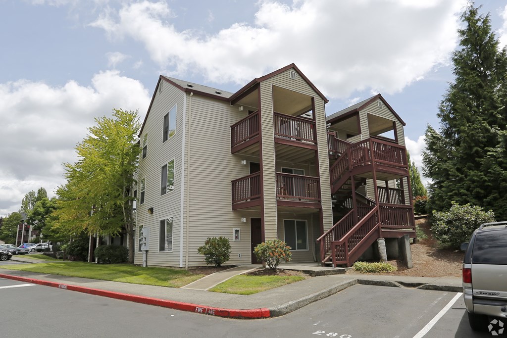 A two story apartment building with a red line on the street in front.