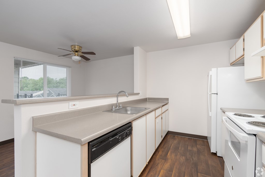 A kitchen with white appliances and wooden cabinets.