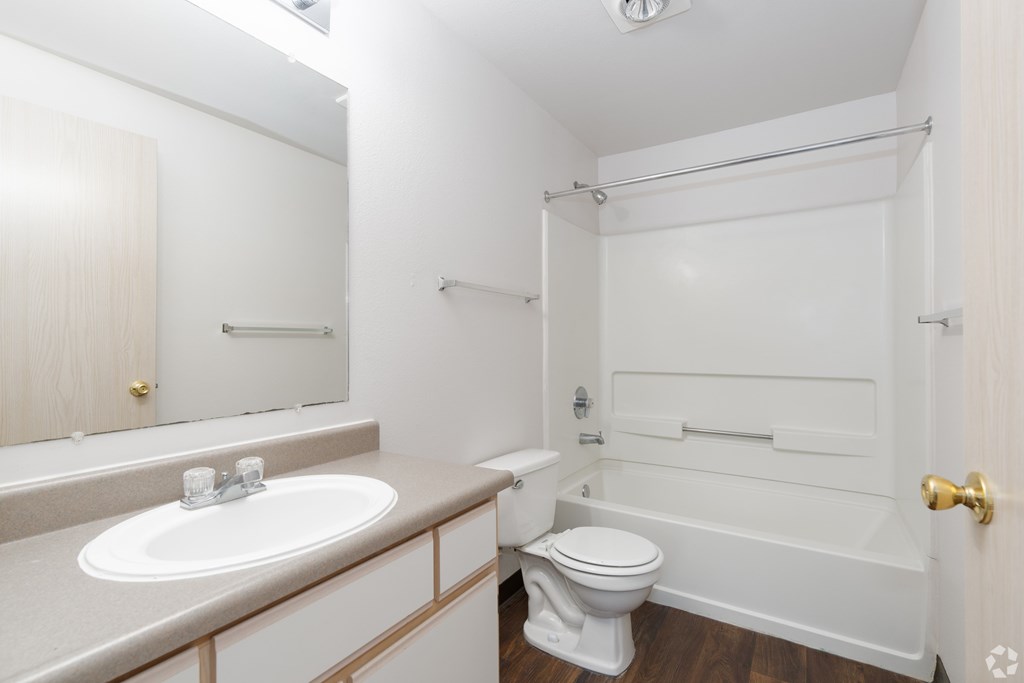 A white bathroom with a toilet, sink, and bathtub.