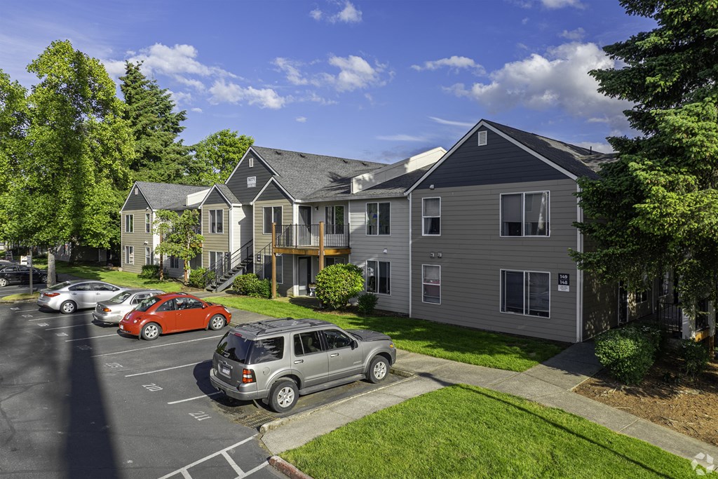 A parking lot with cars and a building in the background.