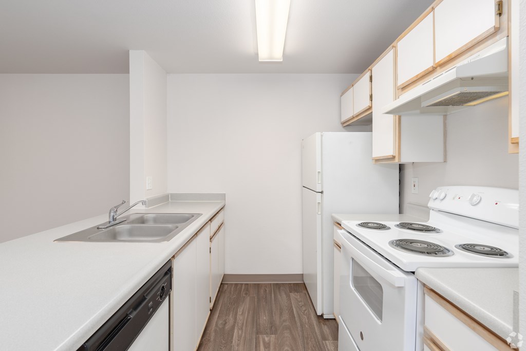 A kitchen with white appliances and cabinets.