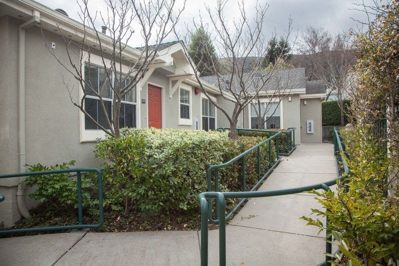 a sidewalk in front of a building with a red door