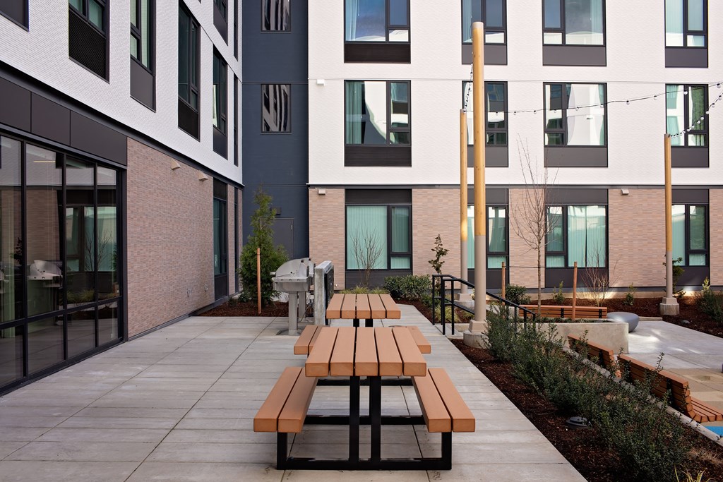 a communal area with benches in front of an apartment building