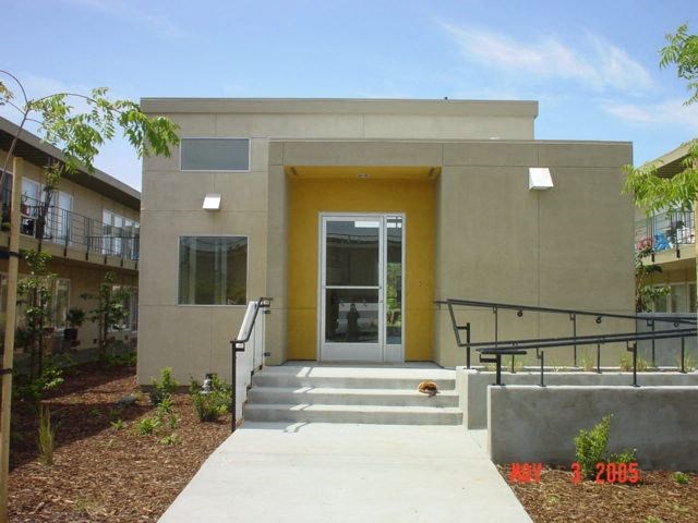 a small building with stairs and a yellow door