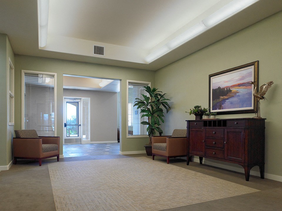 a living room with chairs and a dresser and a painting